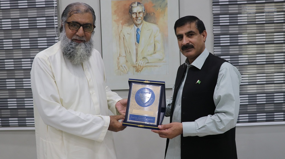 VC UoP Prof. Dr. Muhammad Idrees (Right) presents a souvenir to Prof. Dr. Masoom Yasinzai, Meritorious Professor of Biochemistry and currently the Rector, International Islamic University, Islamabad (IIUI) upon his visit to the University of Peshawar.